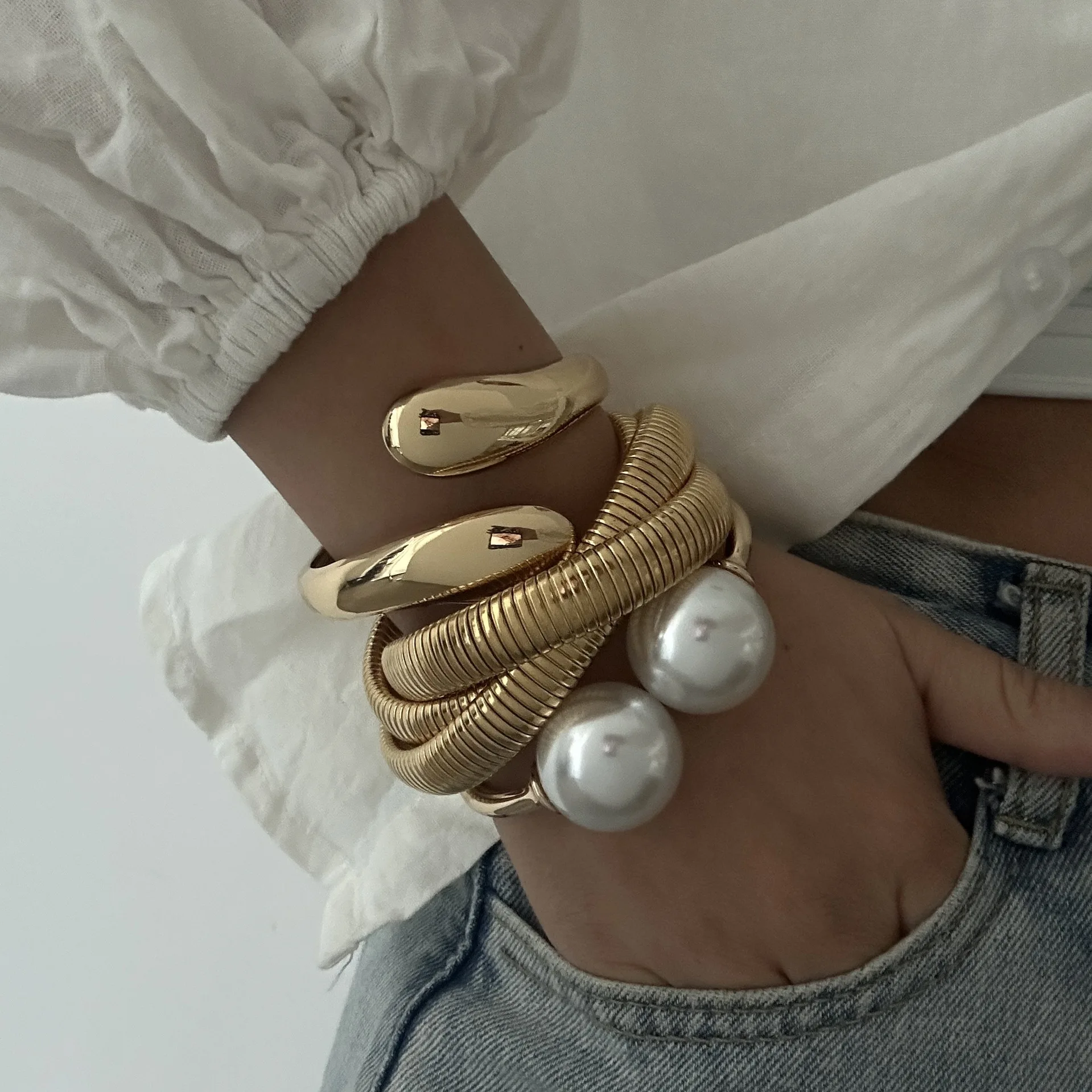 Gold-tone cuff bracelet with pearl ends for women – wide statement bangle with modern fashion appeal.