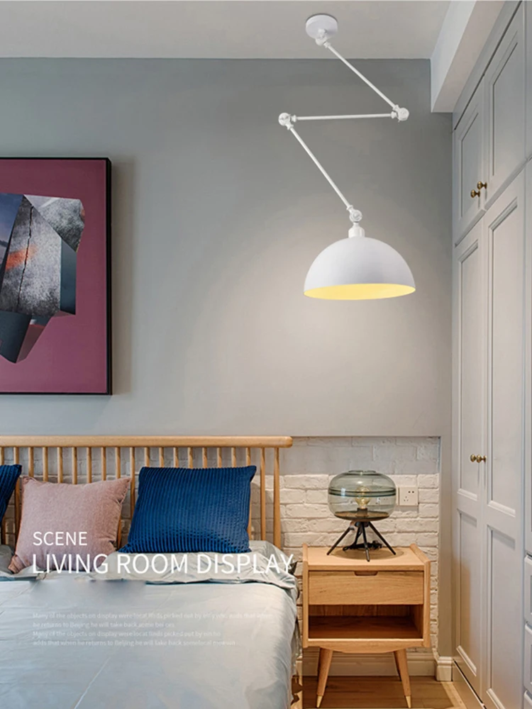 The bedroom showcases a wooden bed adorned with blue and gray bedding in an industrial design. A wall-mounted adjustable arm system lamp offers versatility, while the Zig Zag Pendant Light provides an artistic touch. A round glass table lamp rests on the wooden nightstand, with artwork elegantly above the bed.