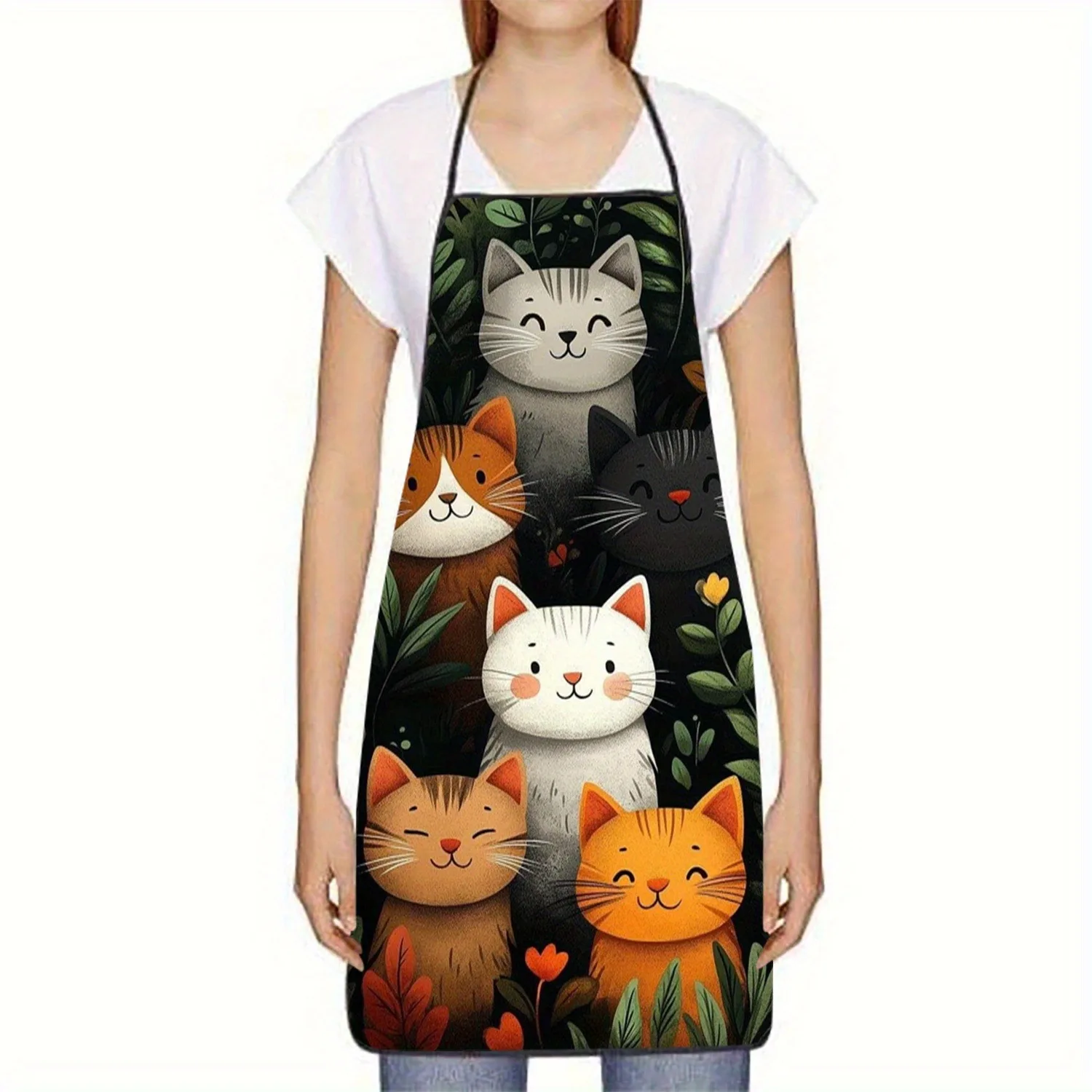 A woman wears the Vibrant Cartoon Cat Polyester Apron by KittyNook Cat Co., featuring six smiling cats with leaves and flowers.