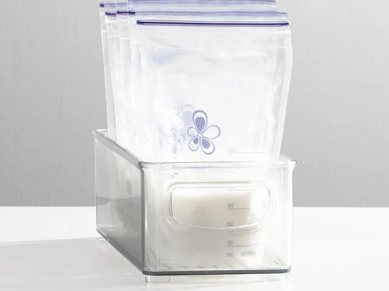 narrow clear plastic baby bins with d shaped handles holding breastmilk bags