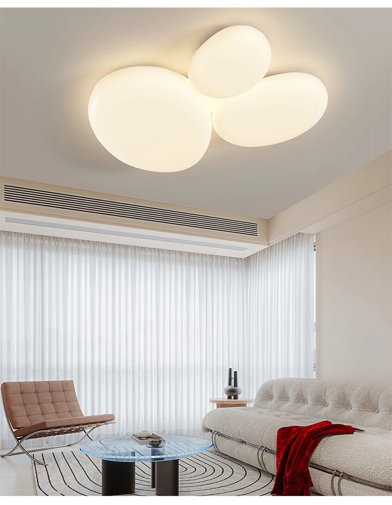 A contemporary room with a minimalist design, featuring a couch and a ceiling light fixture.