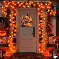Orange maple leaf string lights decorating a Halloween front door with pumpkins and spooky décor