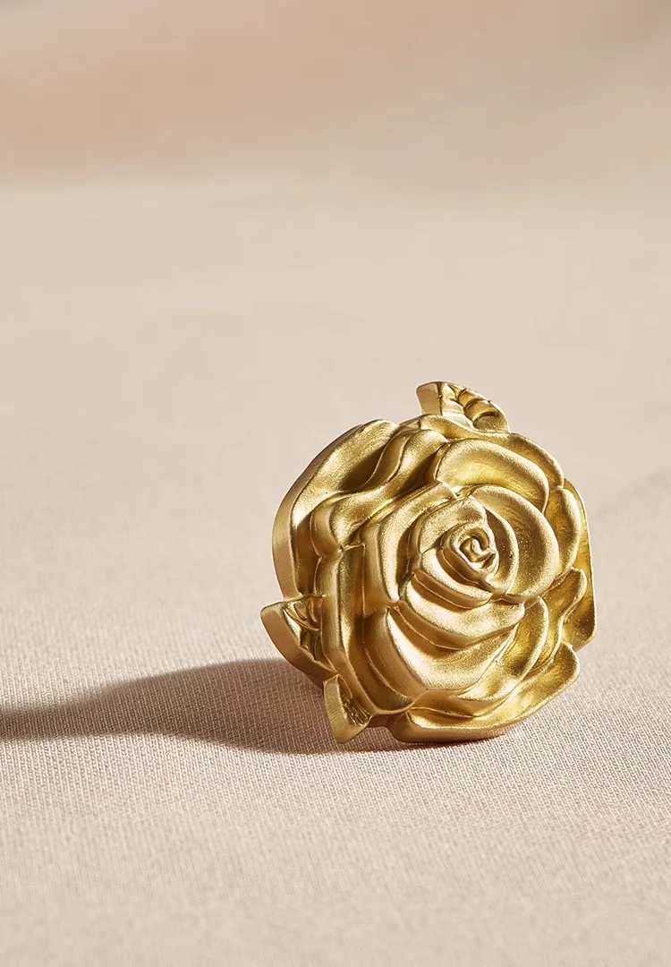 single hole gold cabinet knob with rose pattern