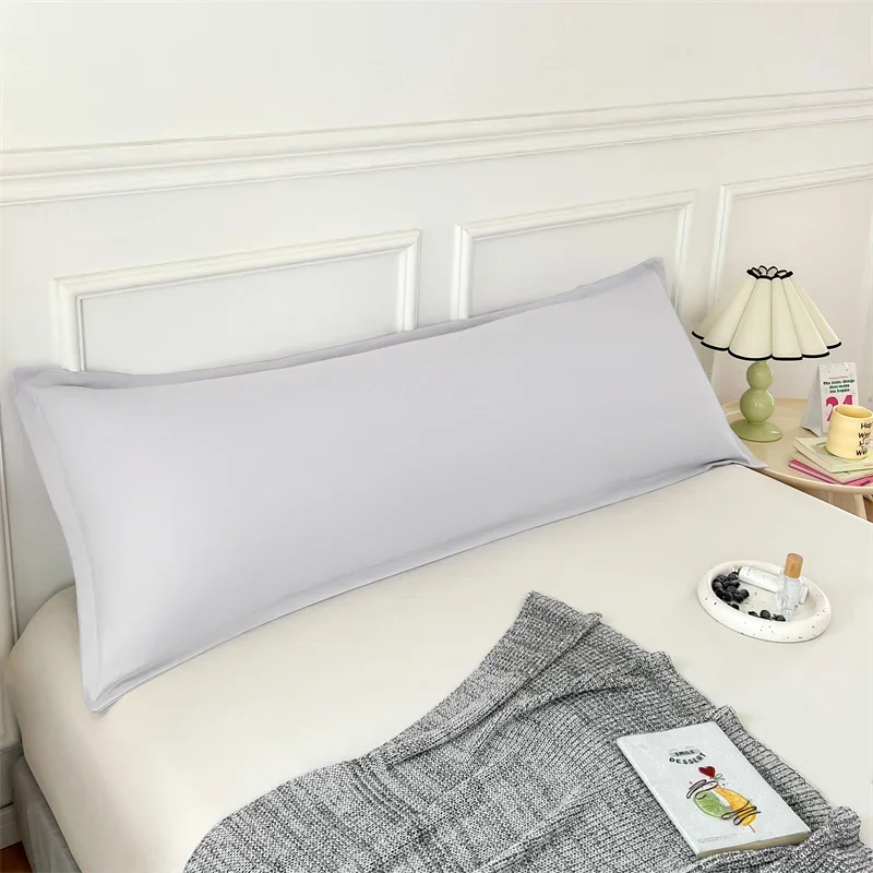 Long rectangular pillow cover styled against a bedroom headboard