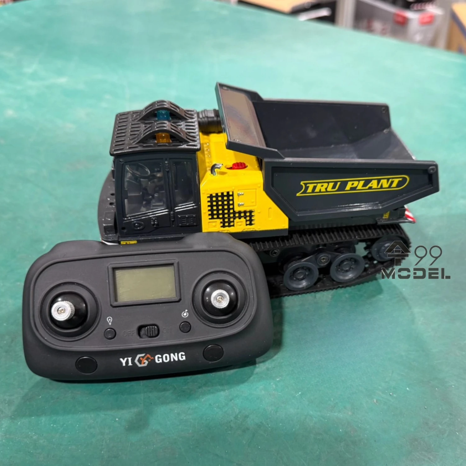 Camion benne basculante télécommandé 1/50 YIGONG en action sur un chantier miniature