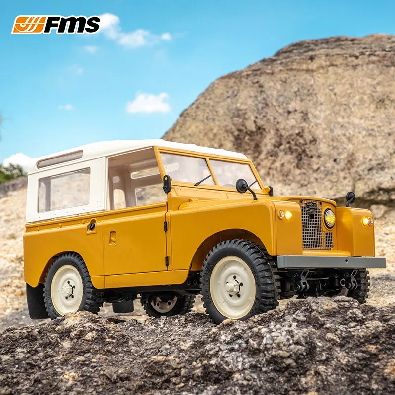Gros plan sur les détails du FMS 1/12 Land II RC Rover 4x4, avec ses phares avant et sa calandre réaliste.