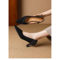 Black Pointed Toe Kitten Heel Pumps Side View Black pointed toe kitten heel pumps worn on foot over beige carpet