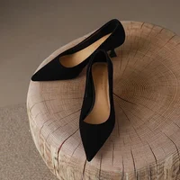 Black Pointed Toe Kitten Heel Pumps Black pointed toe kitten heel pumps displayed on a wooden stool