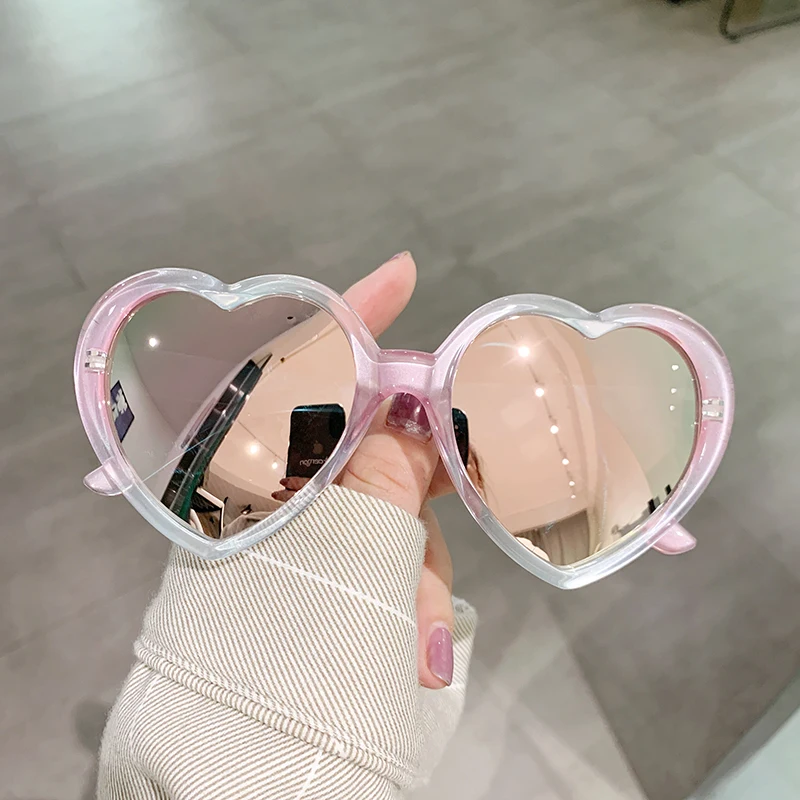 Man wearing suit with pink tie giving a big smooch to the camera behind a  pair of crazy oversized heart-shaped sunglasses Stock Photo - Alamy