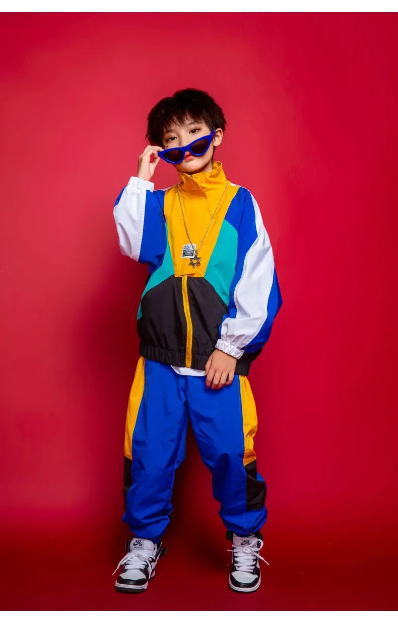 Child wearing patchwork jacket and joggers in hip hop street dance pose32145