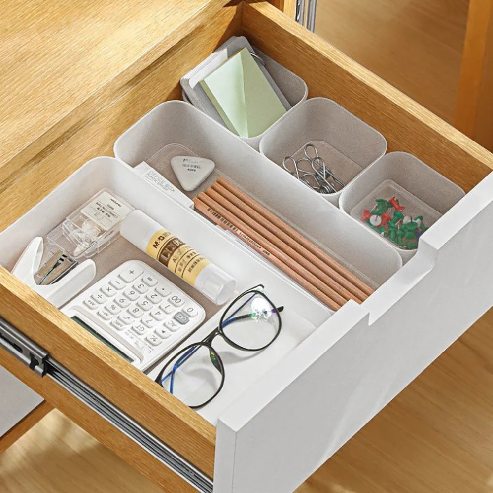 Organizery do szuflad starannie ułożone w szufladzie biurka