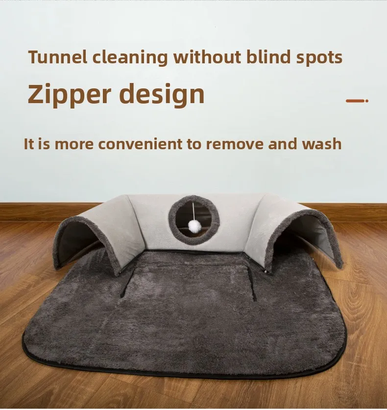 The KittyNook Cat Co. Interactive U-shaped Cat Tunnel, gray and brown with a zipper and ball toy, on a wooden floor.