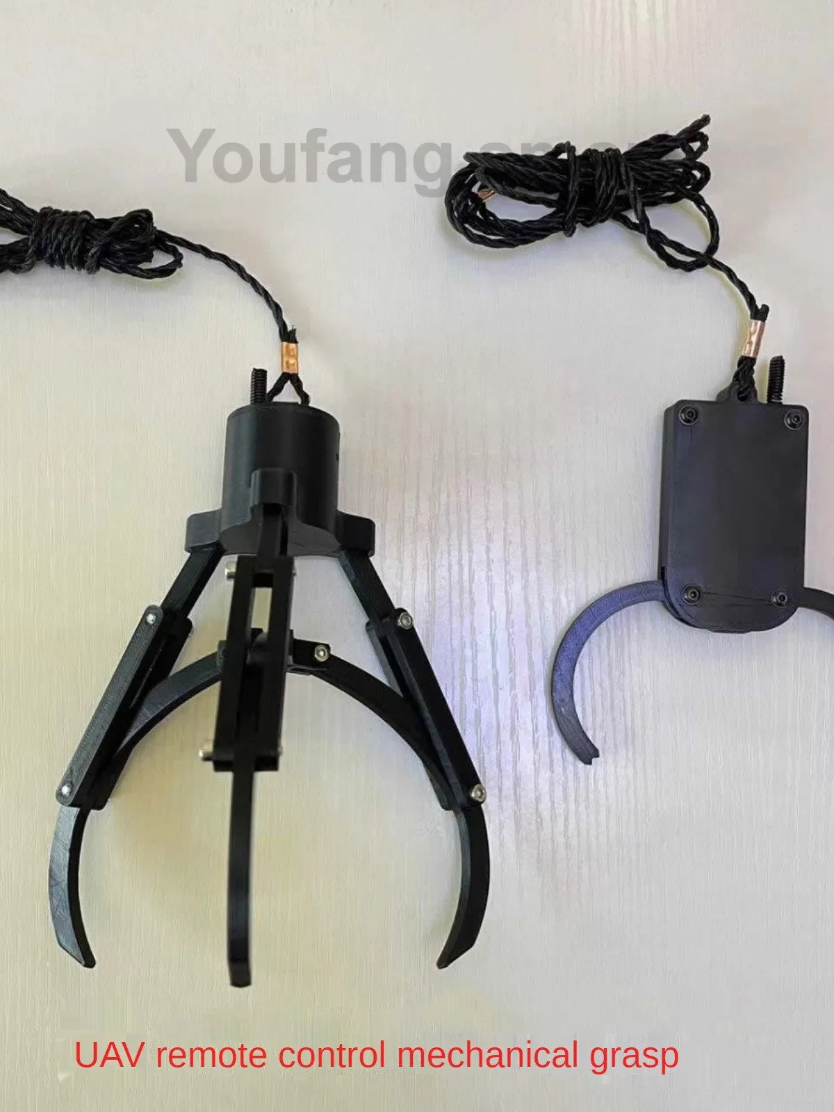 Gros plan sur la pince du bras robot programmable saisissant une petite bille métallique.