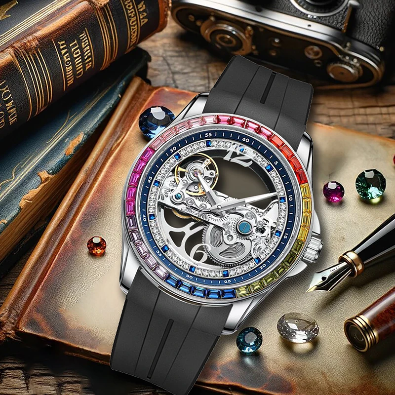 L'Orologio automatico scheletrato tourbillon uomo con strass arcobaleno di PACOSHOP24.COM, con lunetta arcobaleno e cinturino nero, poggia su un vecchio libro tra pietre preziose, una macchina fotografica vintage e una penna stilografica per un'eleganza senza tempo.