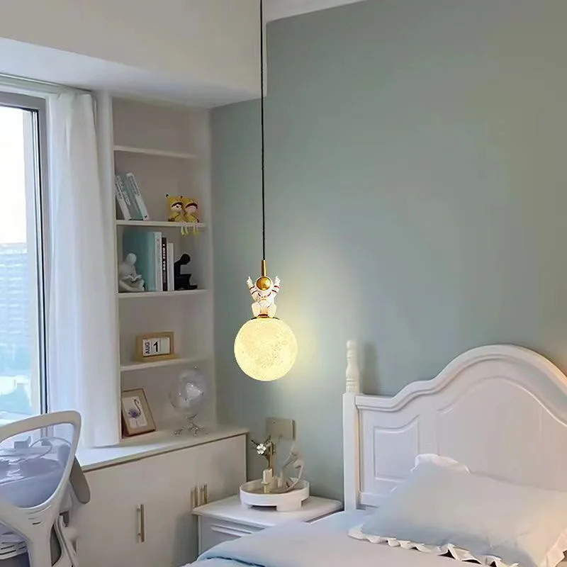 A child's bedroom with a white bed and blue walls, designed to spark imagination and creativity with the addition of an Astronaut Pendant Light hanging from the ceiling.