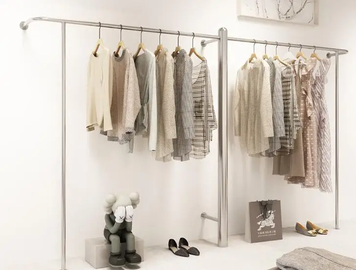 

The display rack of clothing store is floor mounted, and the golden clothes rack is hung on the wall. The women's clothes displa