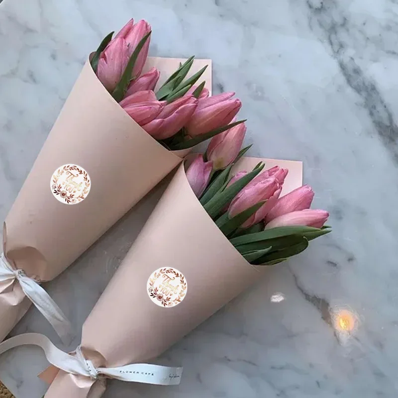 Roll of thank you stickers against a neutral background