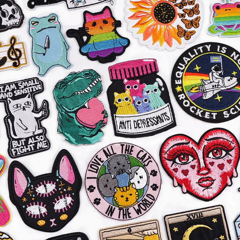 Funny cartoon embroidered patches – cats, dinosaurs, rainbows, quotes, sunflowers, and feminist designs on white background