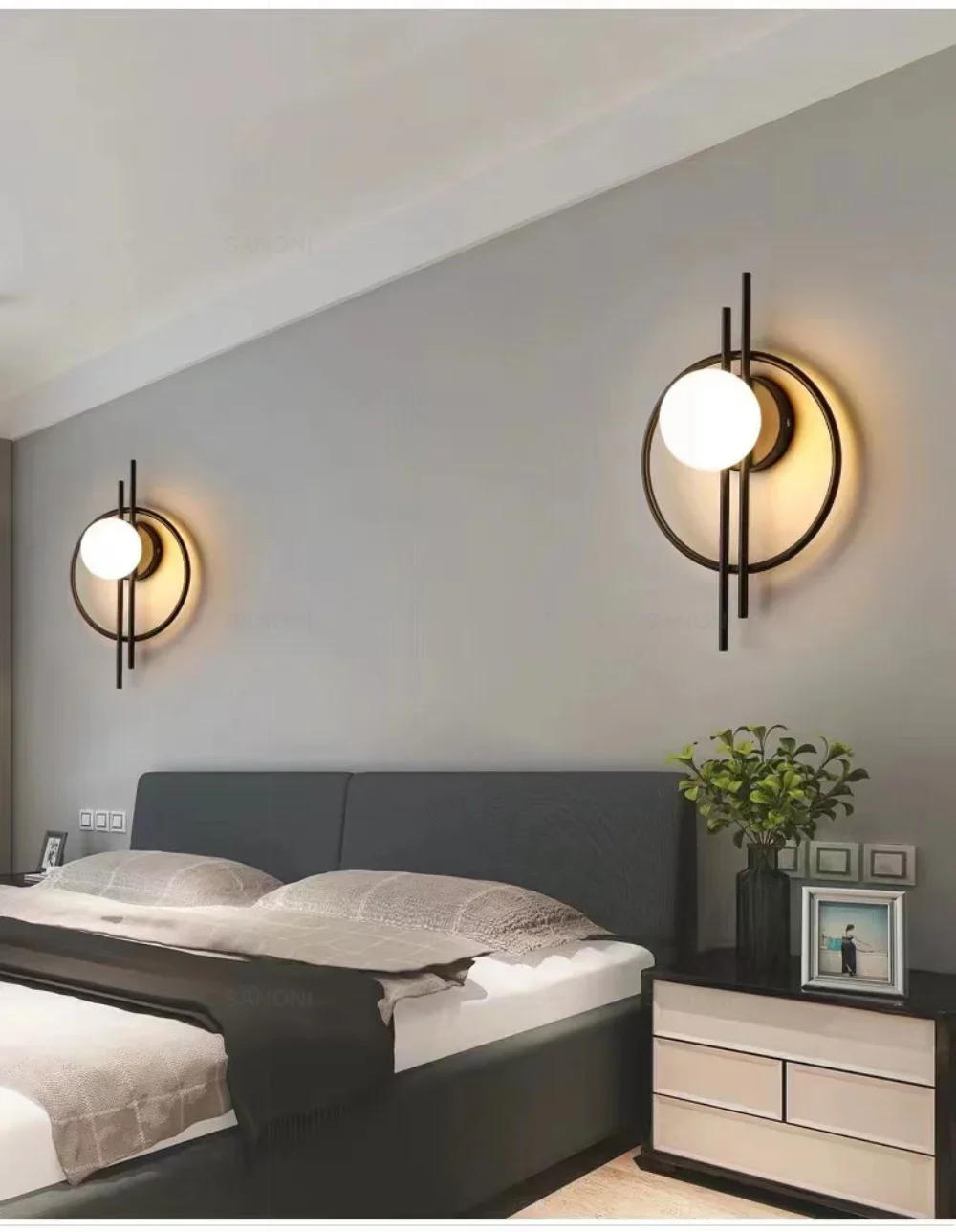A modern bedroom with a double bed, two Circular Wall Sconces with Dual Vertical Rods, a bedside table with drawers, and a potted plant.