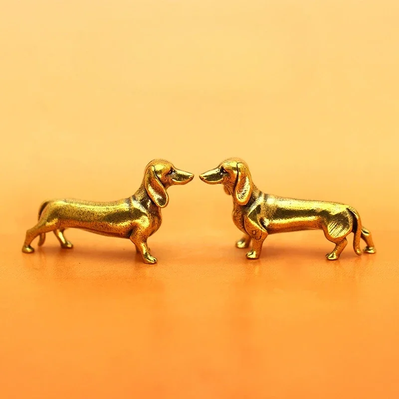  Antique retro copper dachshund miniature statues and vintage brass sausage dog figurines on a display surface.