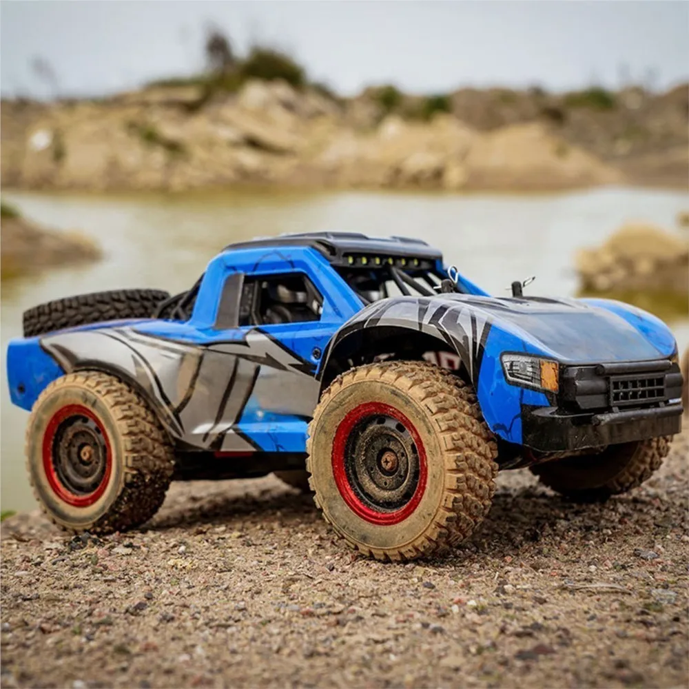 Sous le capot de la voiture télécommandée tout-terrain 48 km/h 4WD Q130A 1/14 - JJRC, avec le moteur et la batterie visibles.