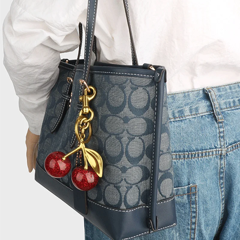 Autentica borsa per accessori Coach con ciondolo ciliegia, nera, borsa