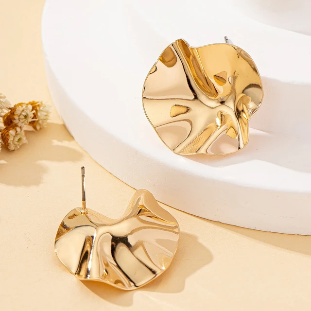 Une paire de boucles d'oreilles en métal rondes irrégulières, bijoux