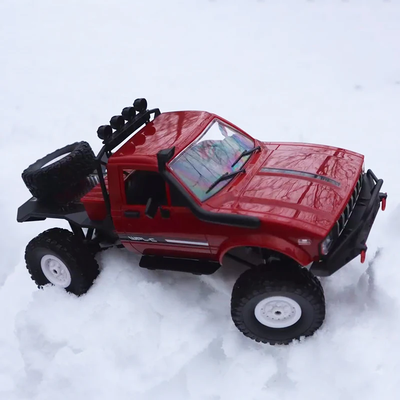 La voiture RC 1/16 4CH 2.4GHz tout terrain C-14 en plein saut, suspension active, dans un décor désertique.
