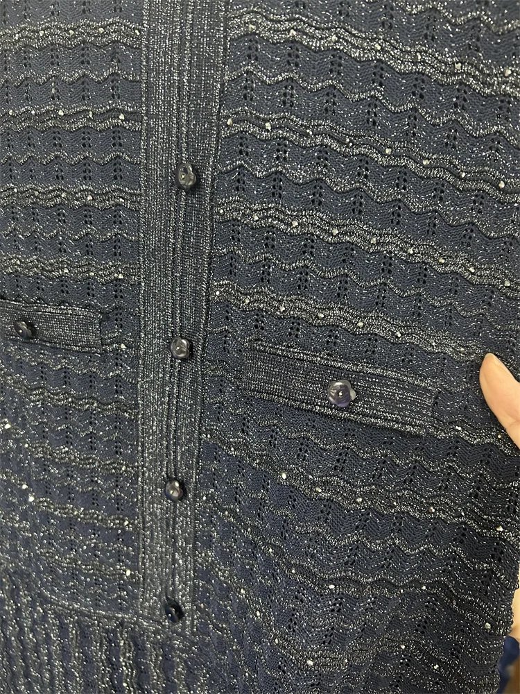 فستان كحلي طويل بتفاصيل لامعة وأكمام واسعة