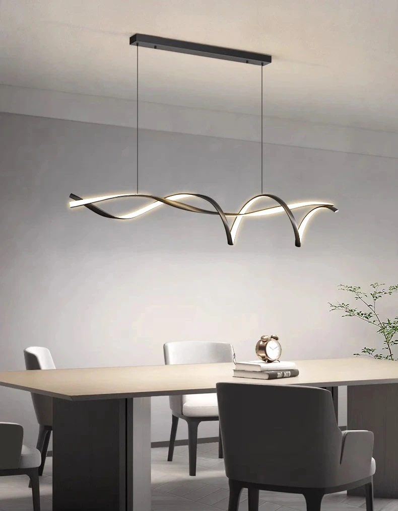 A modern dining room showcases a sleek wooden table with upholstered chairs, enhanced by the Stylish Pendant Light featuring a wave-shaped design. A small clock on the table adds to the contemporary blend of style and function.