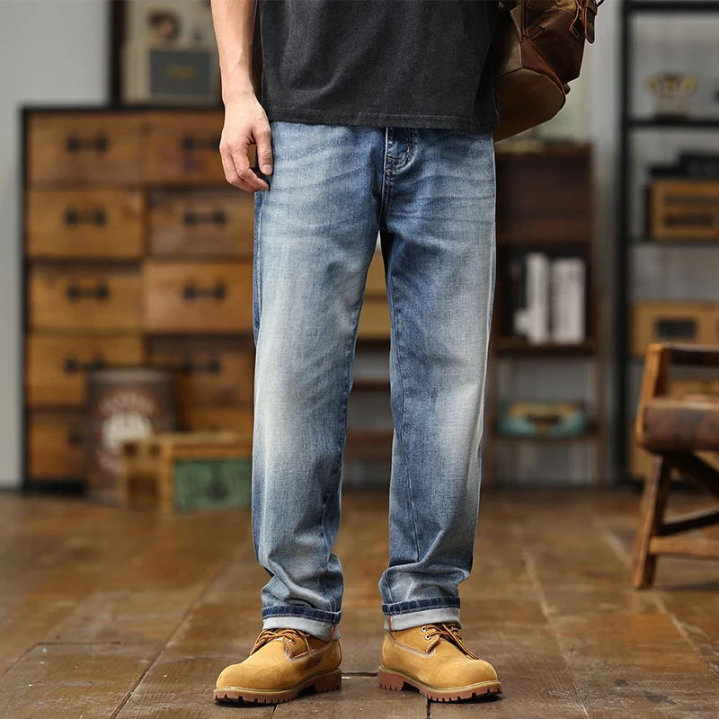 Jeans en denim bleu délavé avec une coupe décontractée et des bas de manche retroussés, présentés comme des pantalons à jambe large en denim bleu clair ample.