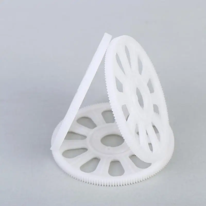 Gros plan sur un engrenage principal 150T blanc pour drone hélicoptère, avec trou central et dents bien définies.