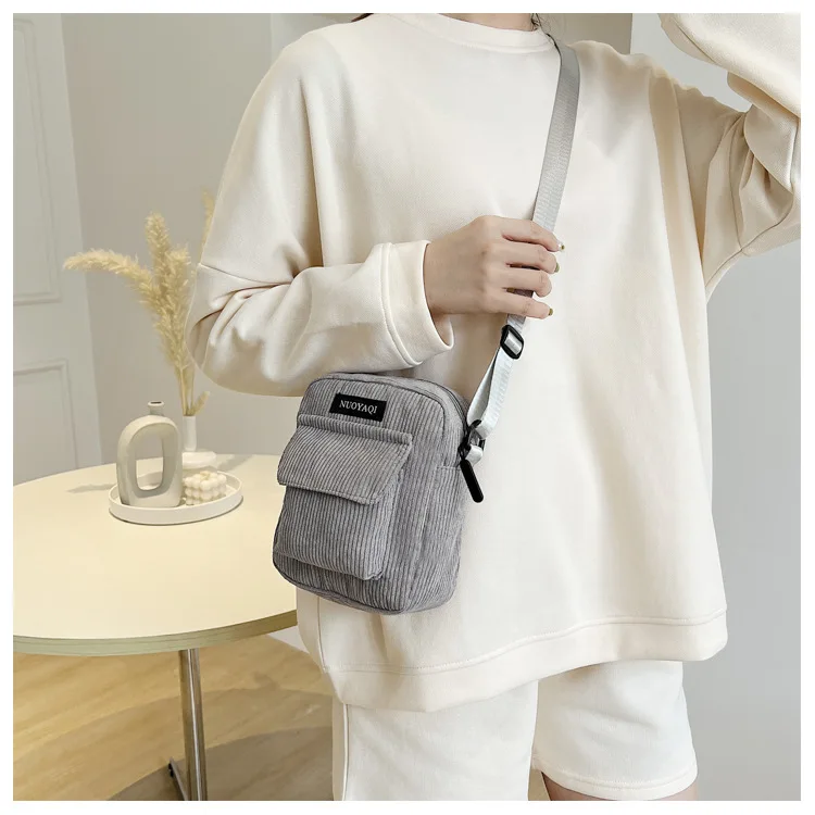 A stylish women’s corduroy shoulder bag with striped fabric design, zip closure, and canvas crossbody strap gray