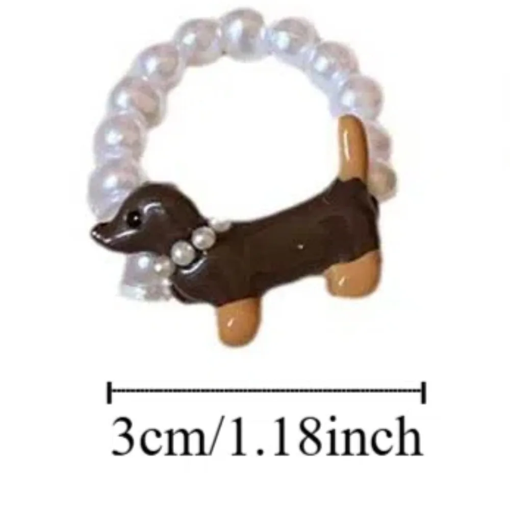 An assortment of cute kawaii dachshund dog jewelry including stud earrings, charm bracelets, and pendant necklaces.