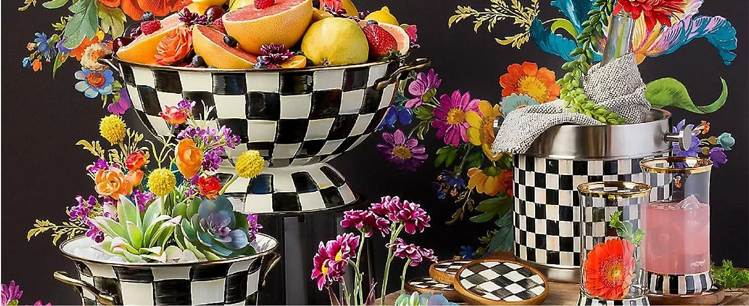 Canister containers and a pitcher sitting on a table with flowers.