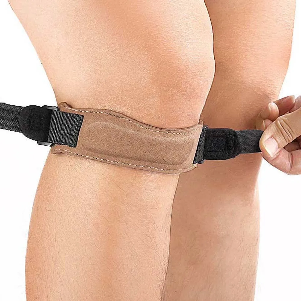 Ceinture de genou patella marron portée sur une jambe, montrant le maintien et la protection genouillère sport