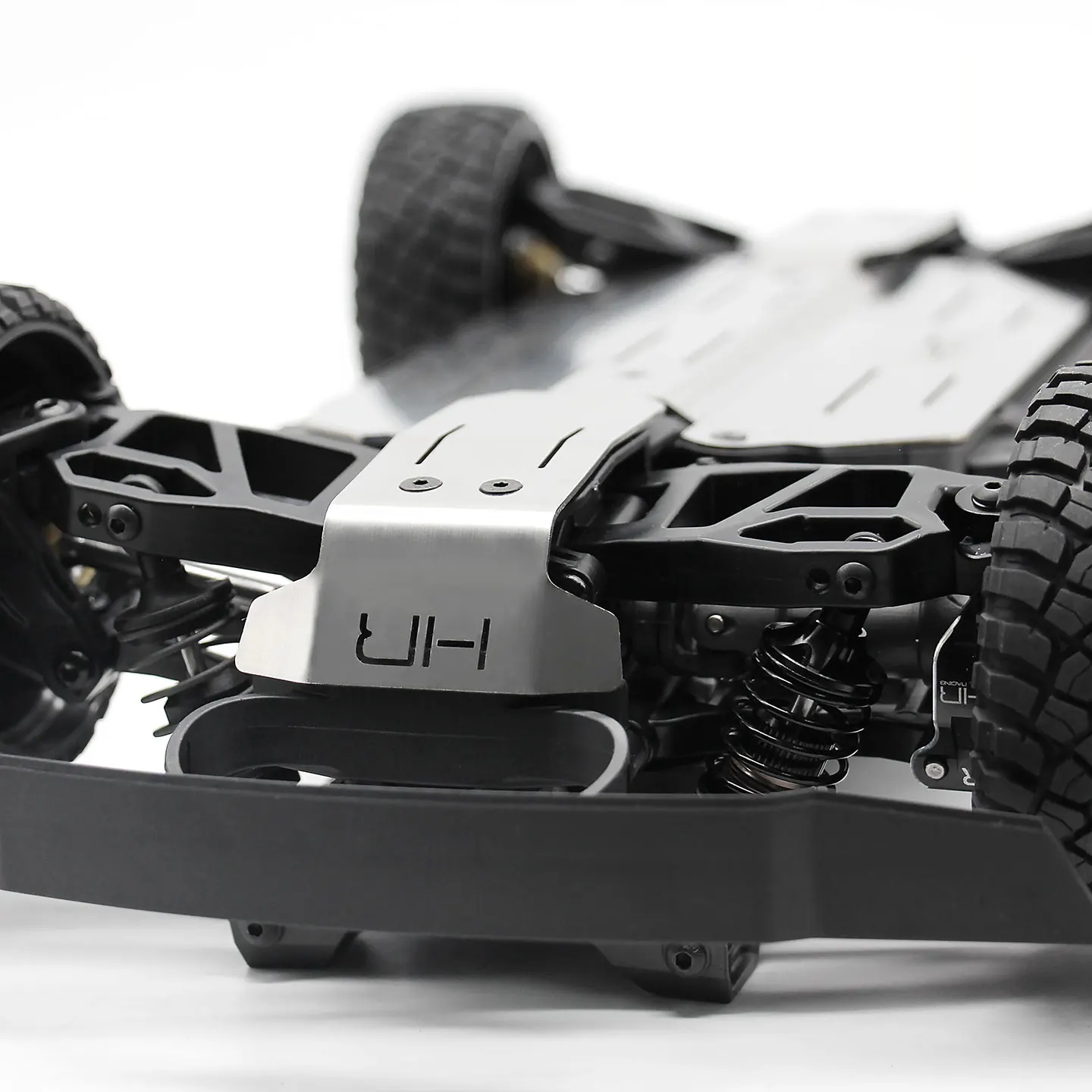 Angle de la plaque de protection inférieure en acier inoxydable pour Traxxas Mini Slash 4x4, montrant les découpes et la finition.