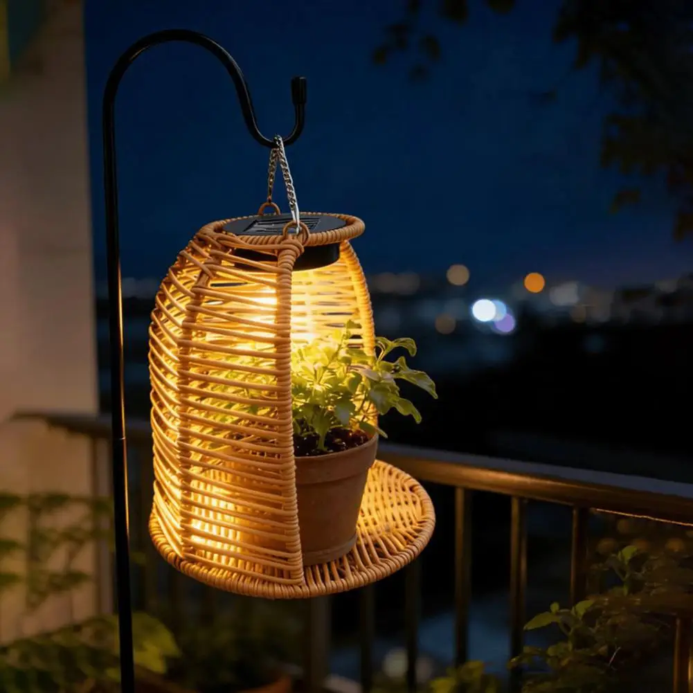 Rattan solar lantern staked into garden flowerbed at dusk