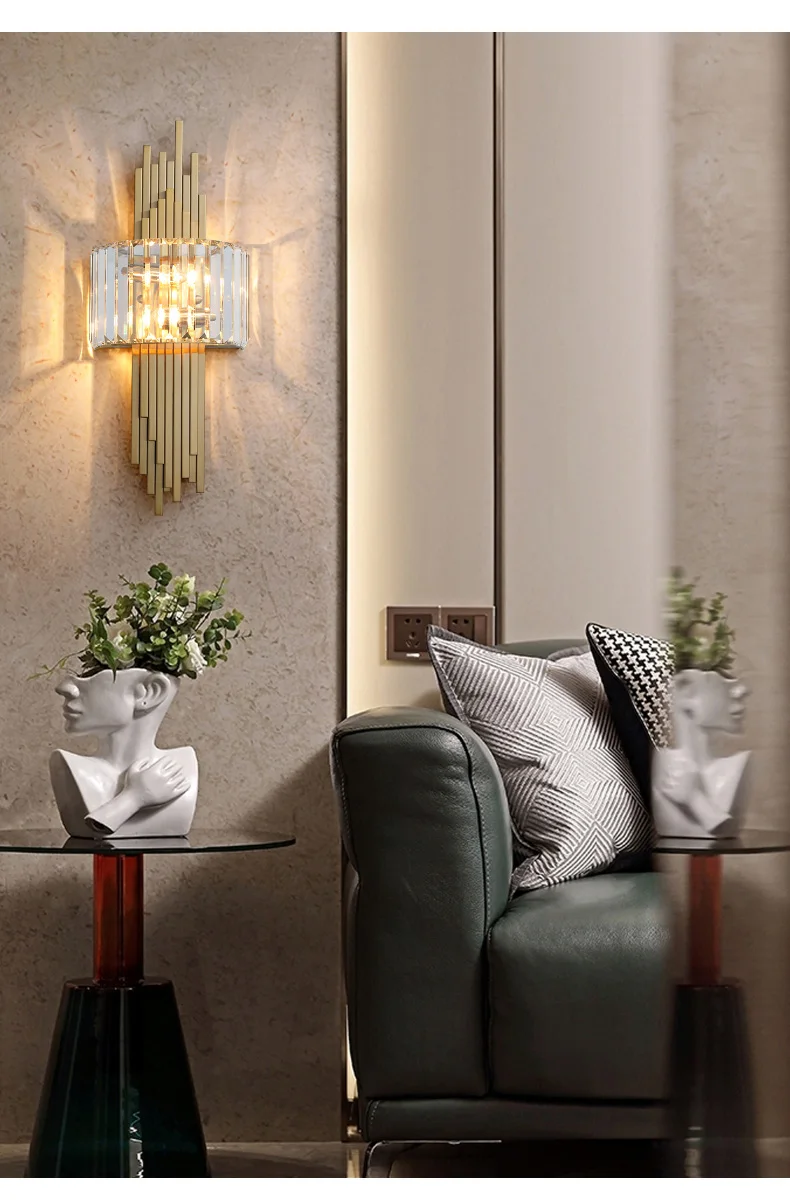 Contemporary living room featuring a green sofa adorned with decorative pillows, a glass side table showcasing a bust vase filled with flowers, and an elegant Luxury Geometric Wall Sconce casting light over the space.