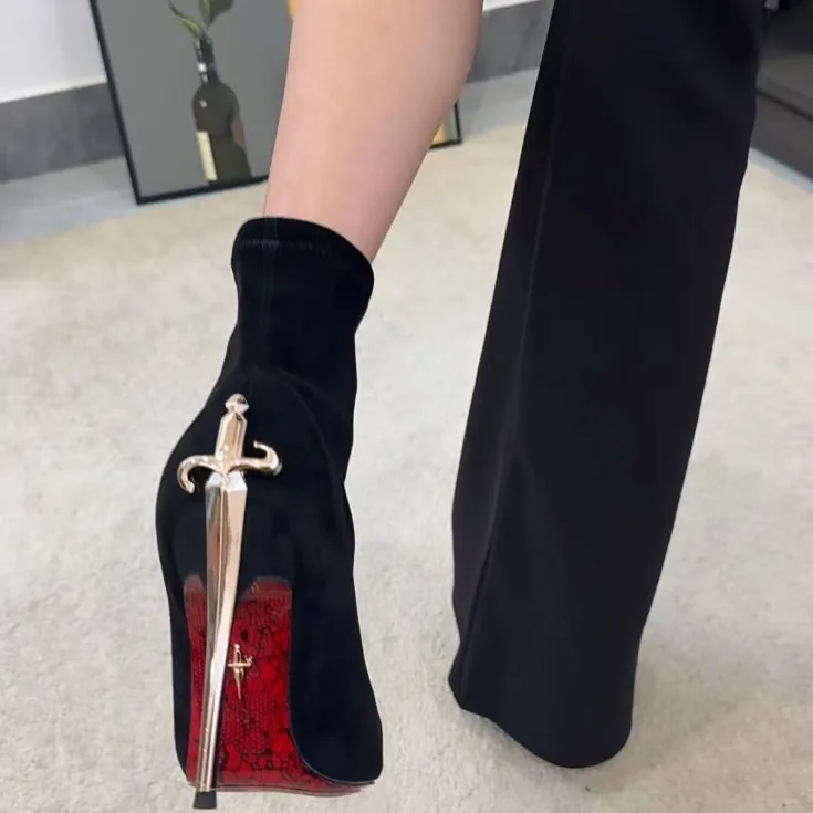 Side profile of velvet red bottom boots