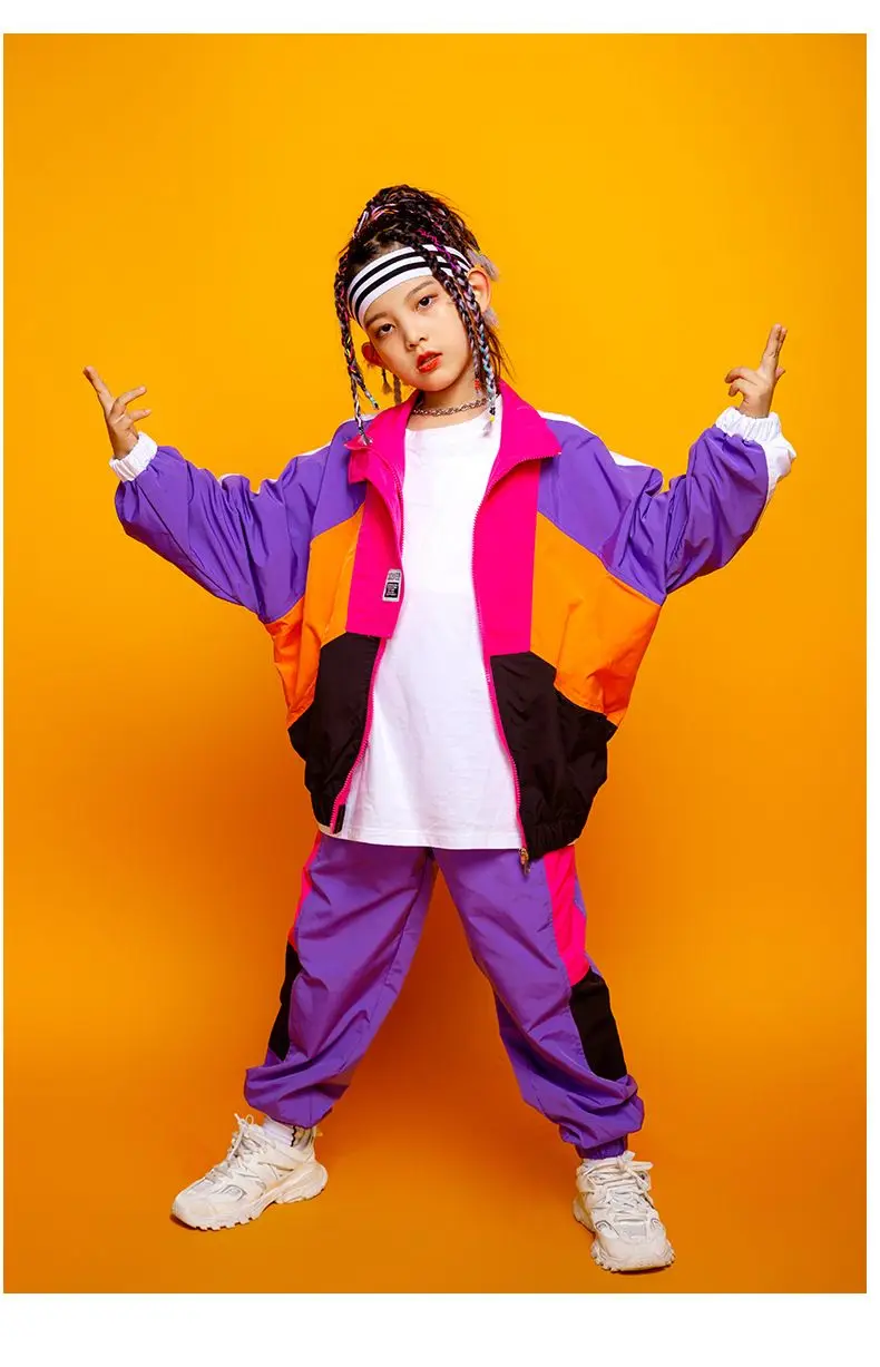Child wearing patchwork jacket and joggers in hip hop street dance pose 6598