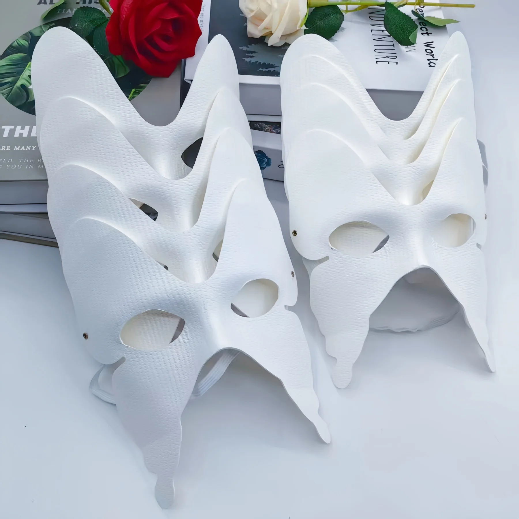 Gros plan sur un masque papillon blanc personnalisable, montrant la texture lisse et les ailes symétriques.