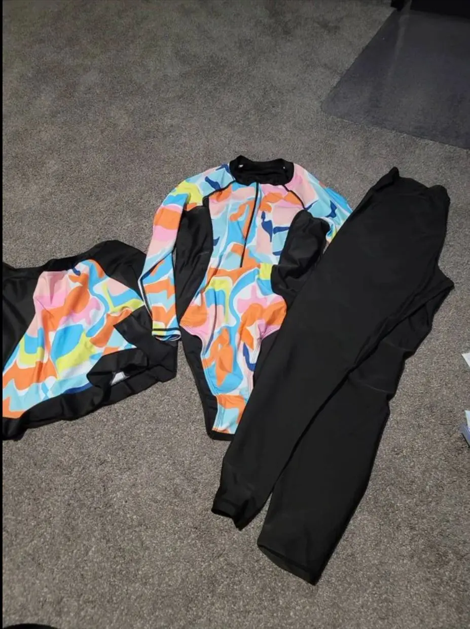 Flat-lay display of 3-piece burkini set with leggings, top, and skirt.