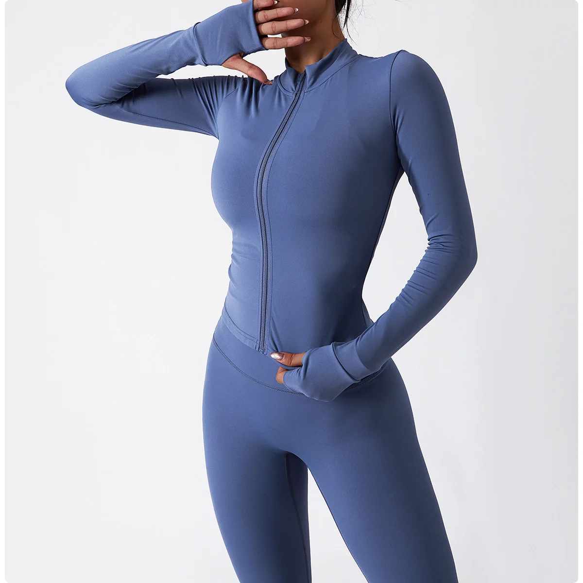 A woman wearing a blue women's tracksuit set sold by 100 Spartans