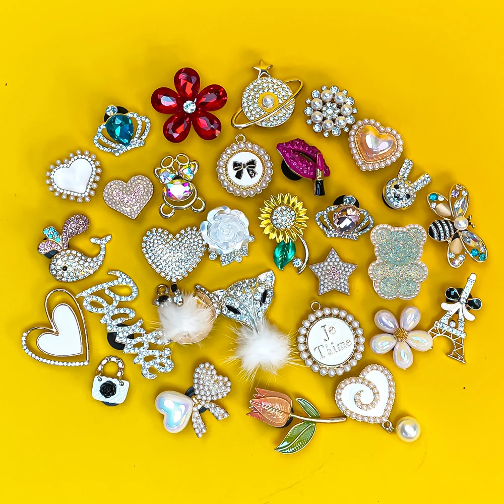 Collection of various decorative metal shoe charms on a yellow background
