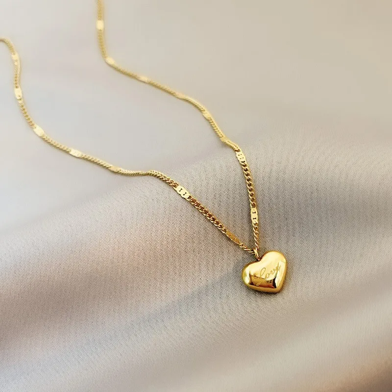 Shop the Trendy Gold Heart Pendant Choker Necklace for Women. Elegant and stylish, this zinc alloy necklace features a delicate heart pendant on a thin link chain, perfect for any occasion. A must-have fashion accessory for women