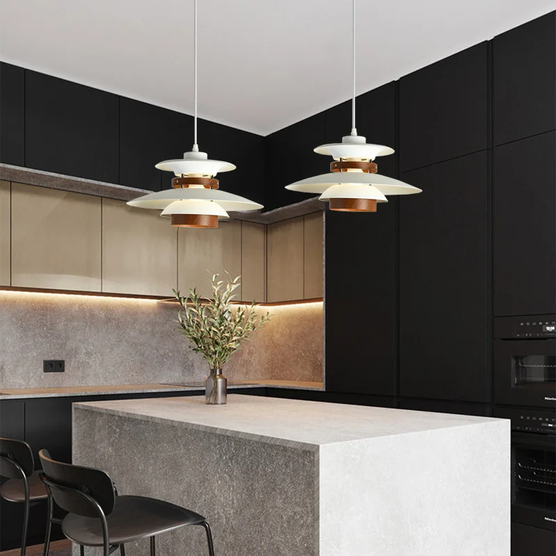 A modern Scandinavian kitchen with black cabinets, white counter tops, and natural wood accents.