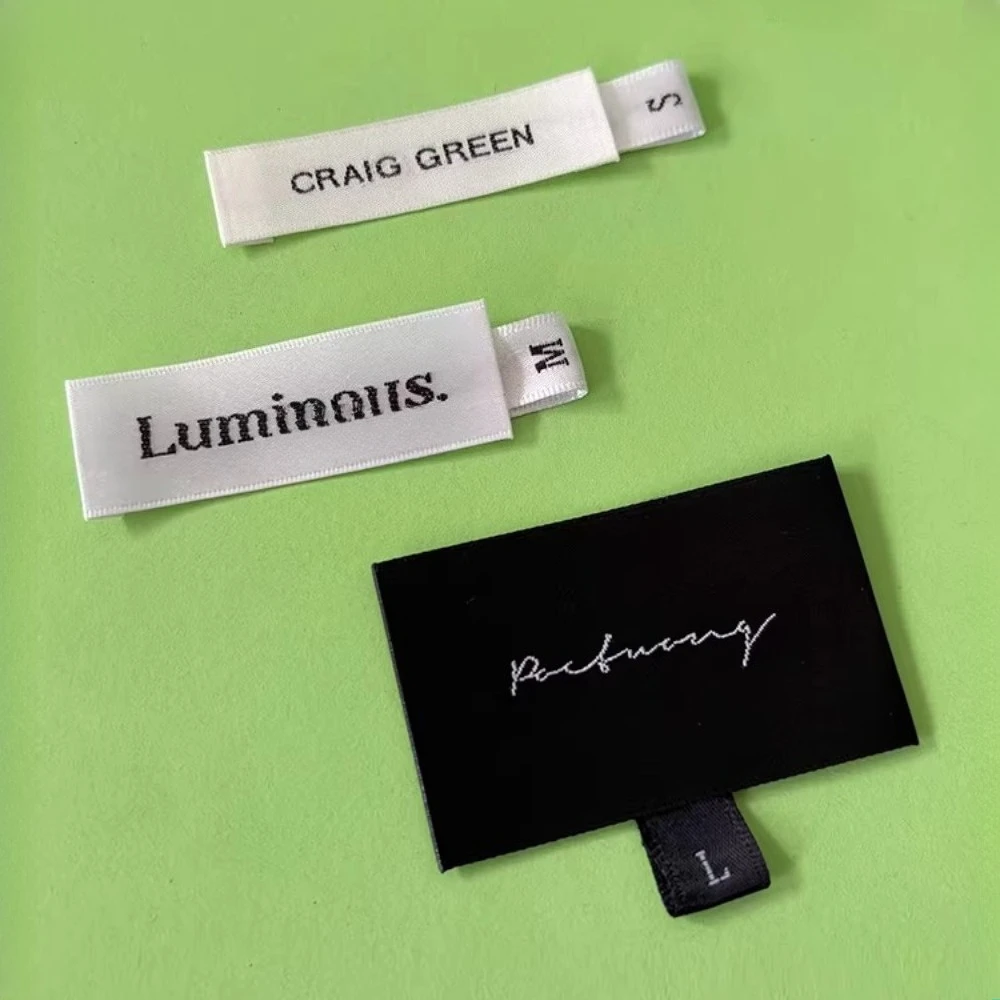 500개/묶음 1.2x3cm 직조 사이즈 라벨 |   셔틀 룸 새틴 원단 |   XS-6XL 사이즈 범위 의류용 흰색/검은색 배경