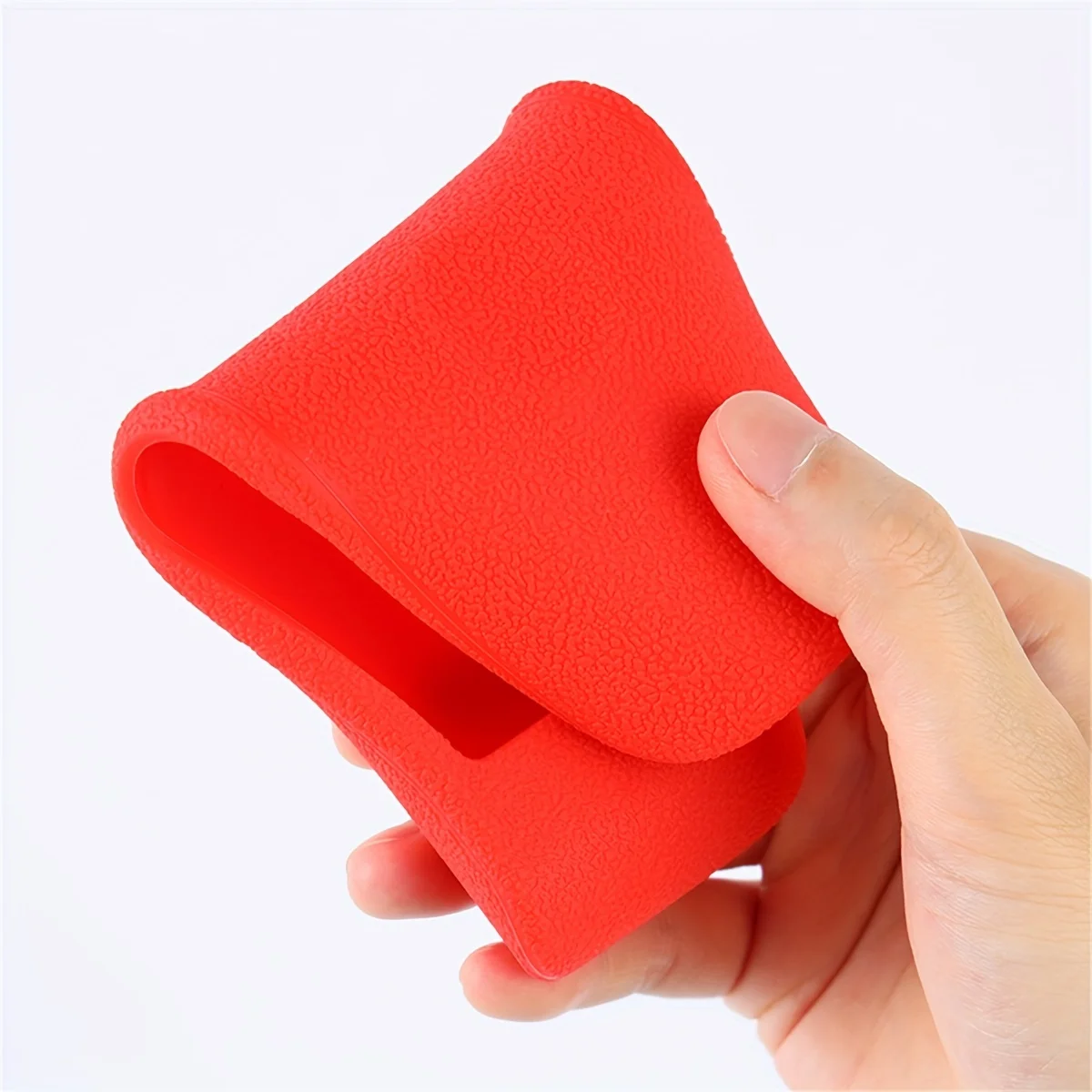 Hand holding Samsung remote with silicone cover on it