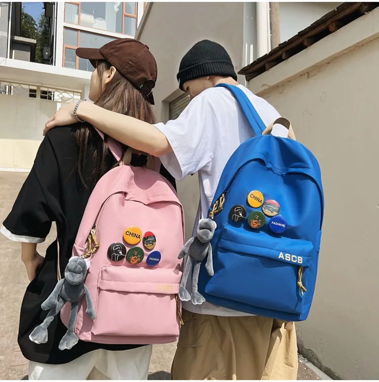 

Backpack female college students simple couples travel backpack leisure junior high school students fashion medal bag